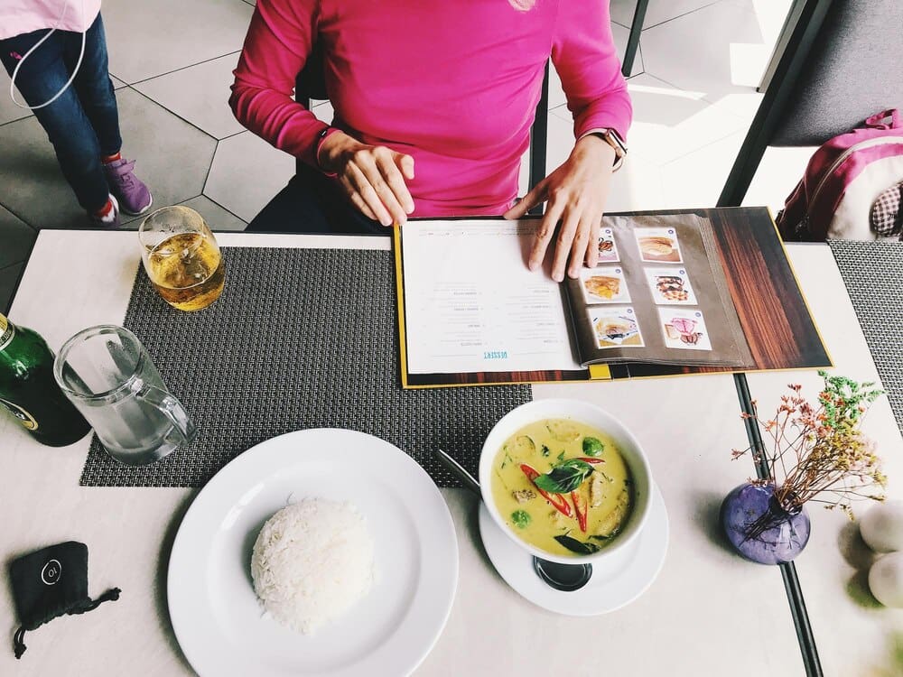 High-angle view of a woman seated at a restaurant table, eating food.
