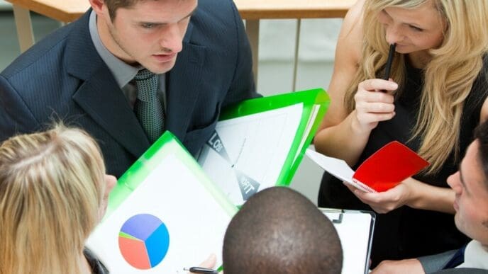 High-angle shot of a young business team in a meeting, seated on outdoor stairs.