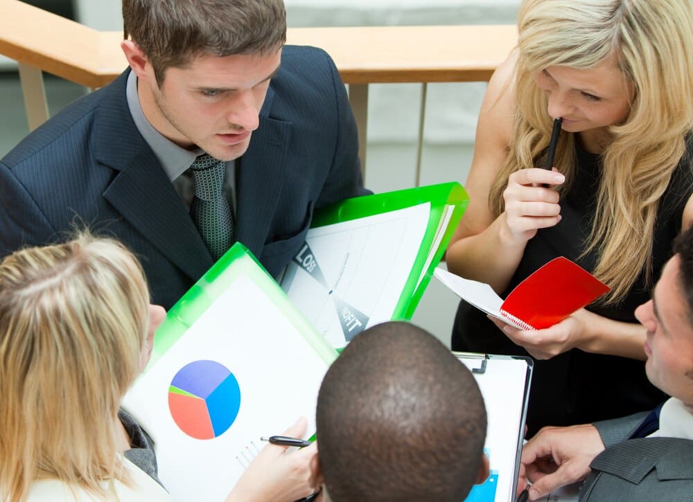 High-angle shot of a young business team in a meeting, seated on outdoor stairs.