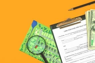 Top-down photo of a clipboard and a land sale and purchase agreement form on an office desk with real estate-related documents.