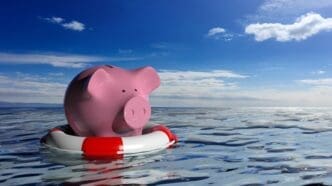 A red life buoy rests next to a white piggy bank on a blue sea, rendered in 3D.