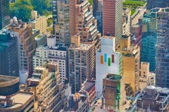 View from above of New York City skyscrapers illuminated by morning sunlight.