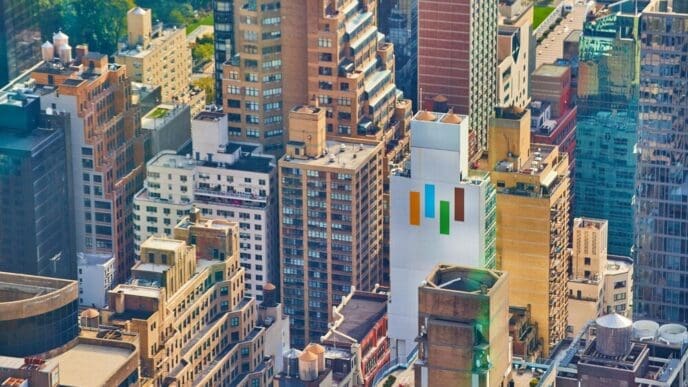 View from above of New York City skyscrapers illuminated by morning sunlight.