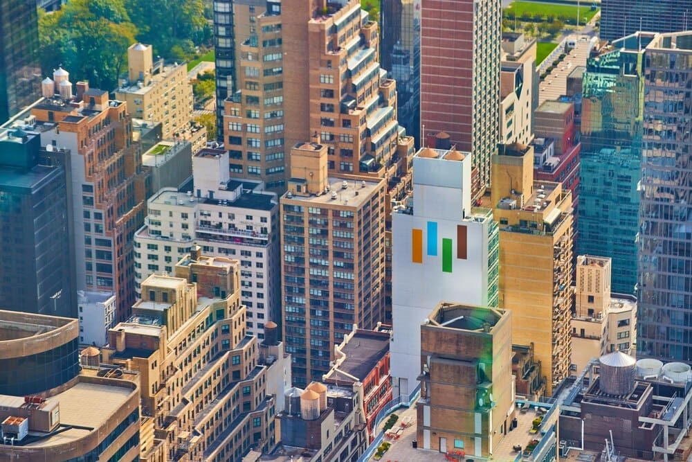 View from above of New York City skyscrapers illuminated by morning sunlight.