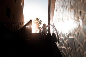 A woman climbs a flight of stairs, viewed from a low angle.