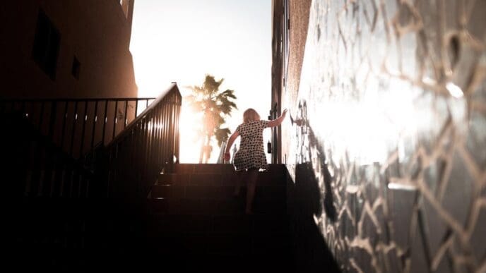 A woman climbs a flight of stairs, viewed from a low angle.