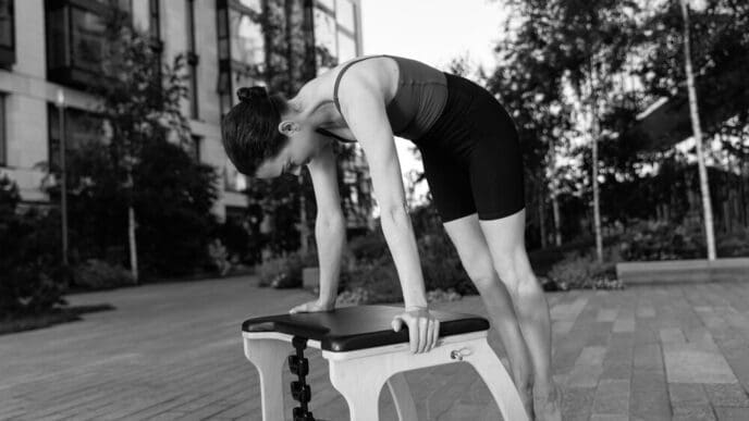 A man's legs and feet are visible as he exercises in a gym.