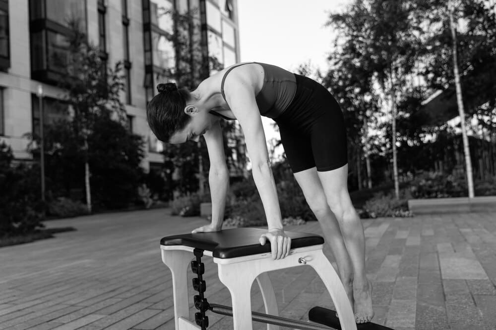 A man's legs and feet are visible as he exercises in a gym.