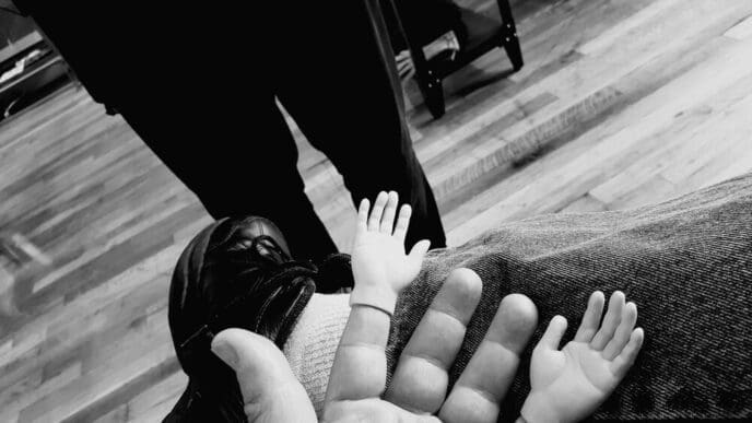 Low-angle view of a person's legs and feet standing on a checkered tile floor.