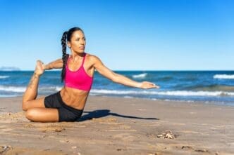 A middle-aged woman exercises on a sunny beach.