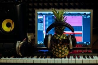 A pineapple wearing headphones appears to be producing music.