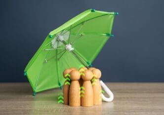People sheltering under an umbrella.