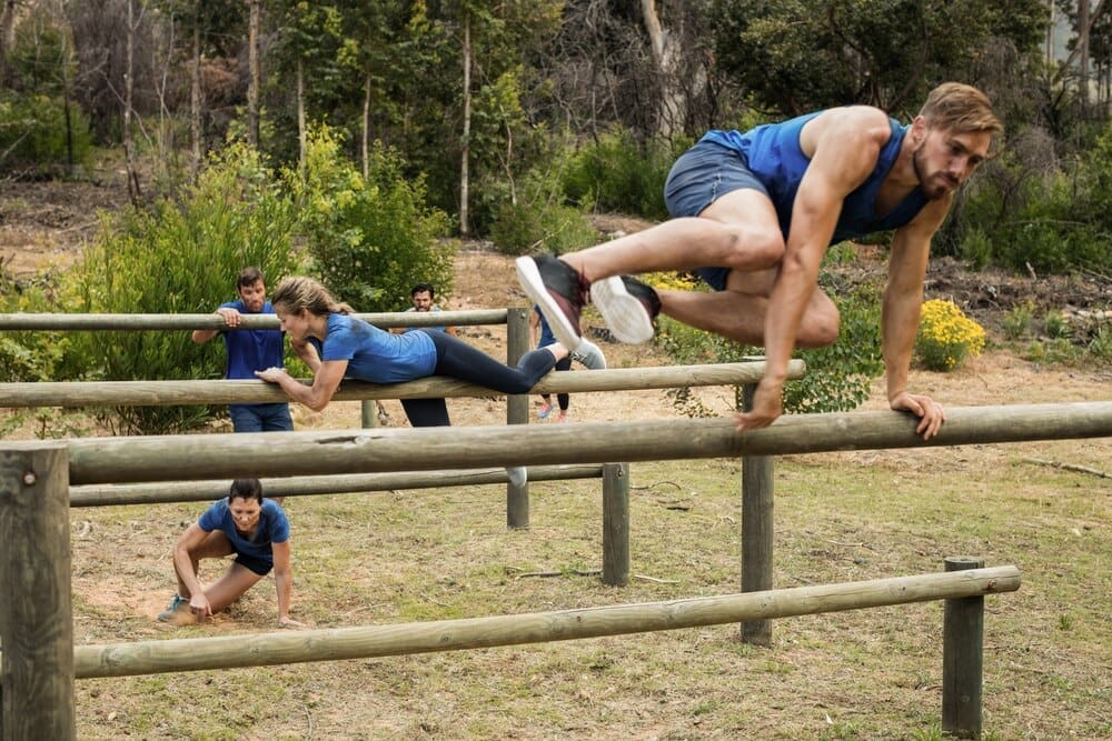 People leaping over hurdles while participating in an obstacle course.