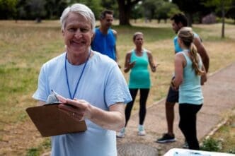 A man smiles while holding a clipboard.