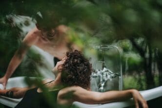Shirtless woman in water, looking directly at the viewer.