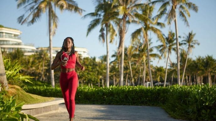 A woman with her hair in a ponytail jogs on a path.