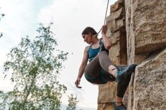 Close-up of professional women's rock climbing, showing hands gripping the rock face.