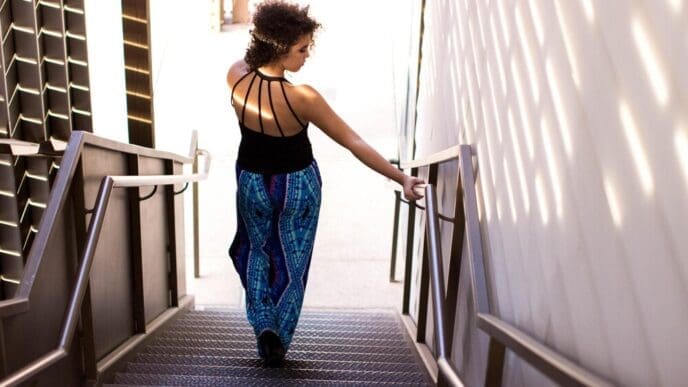 Rear view of a woman descending a flight of stairs.