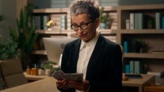 A mature Caucasian businesswoman with gray hair wears a serious expression.