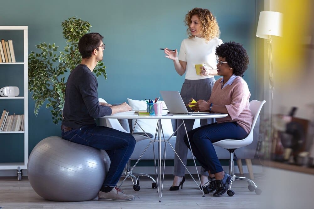 Young businesspeople collaborate on a new project in a casual office setting.