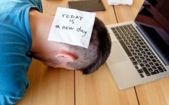 A person sleeps peacefully in their home office, likely a freelancer taking a nap.
