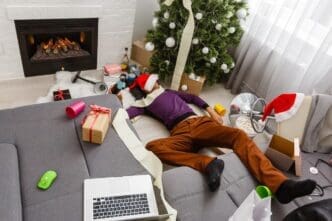 A man sleeps on a sofa, presumably after a Christmas party.