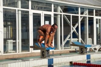 A swimmer is in a large outdoor swimming pool.