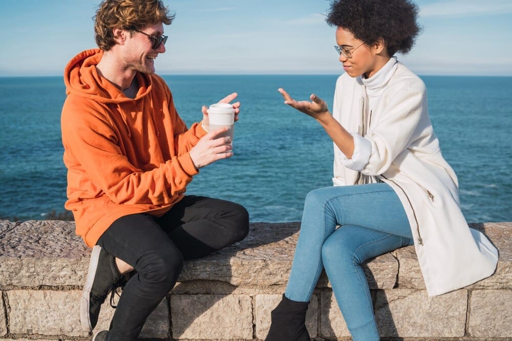 Two friends laughing and smiling while enjoying an activity together.
