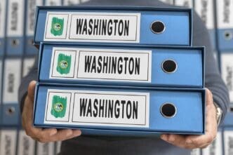 A stack of manila file folders labeled "Washington Administrative Files" sits on a desk.