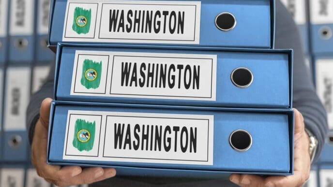 A stack of manila file folders labeled "Washington Administrative Files" sits on a desk.