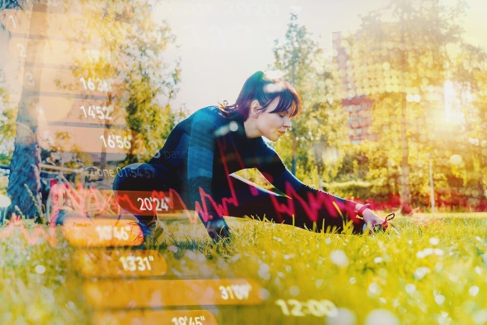 A woman stretches outdoors on a sunny day, likely at a gym or park.