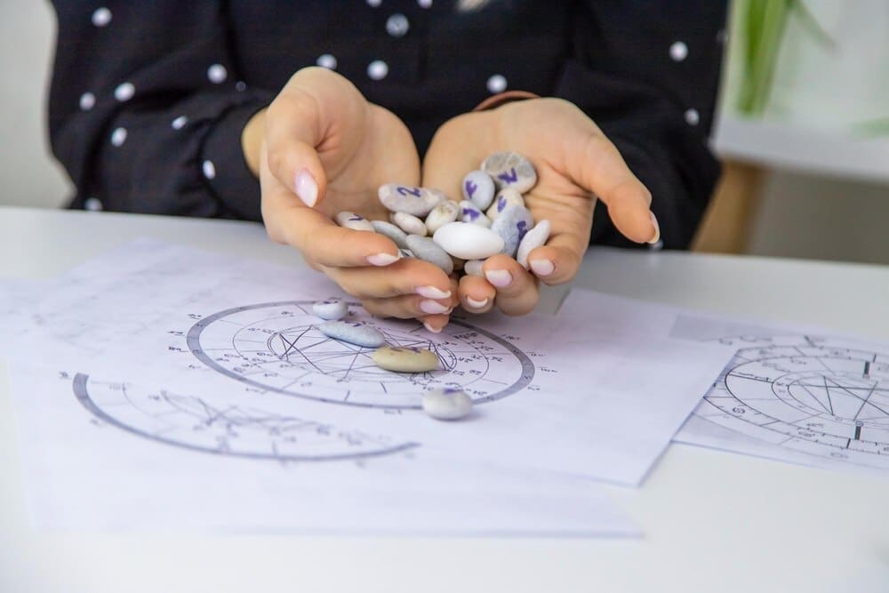A woman, a numerologist and astrologer, counts numbers, with a selective focus on her hands.