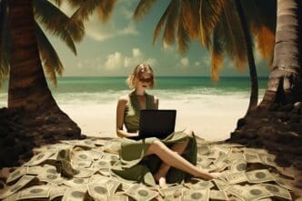 A woman sits on a beach with a laptop open in front of her.