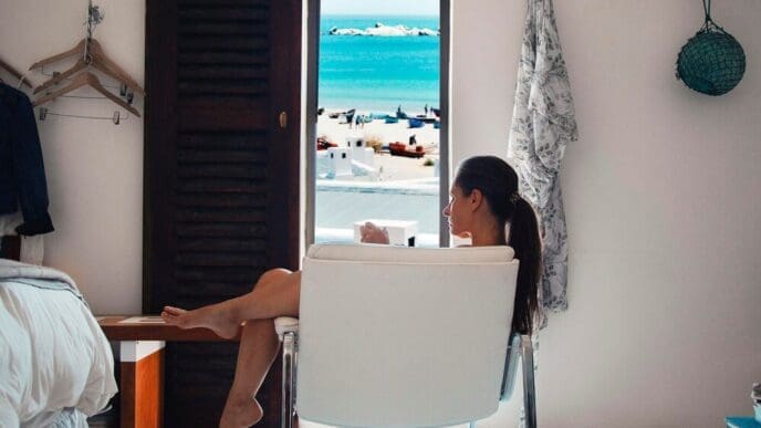 A woman sits on a table indoors.