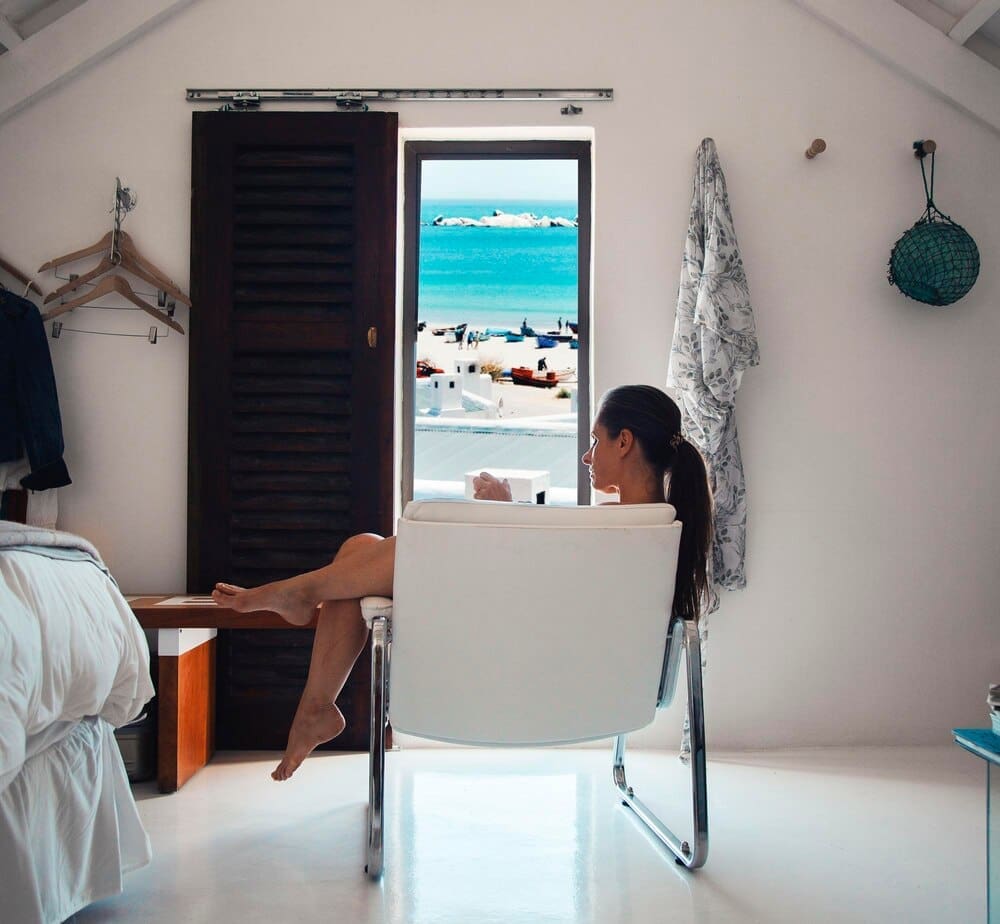 A woman sits on a table indoors.