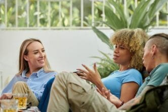 A woman animatedly gestures while telling a story to her friend.