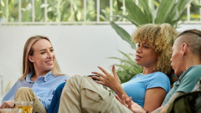 A woman animatedly gestures while telling a story to her friend.