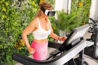 A woman wearing a VR headset runs on a treadmill in a gym.