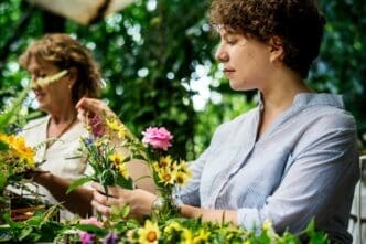 Women arranging flowers in a well-lit room.