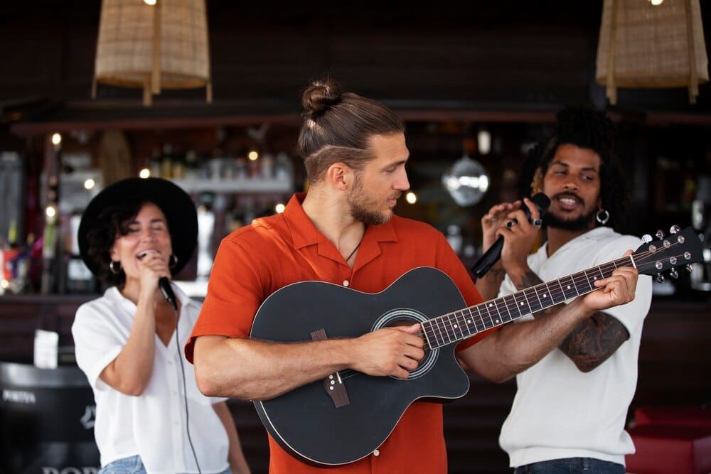 Young adults laugh and smile while enjoying an open mic night.