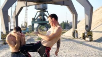 Young, shirtless male boxers practice boxing techniques, likely sparring or training.