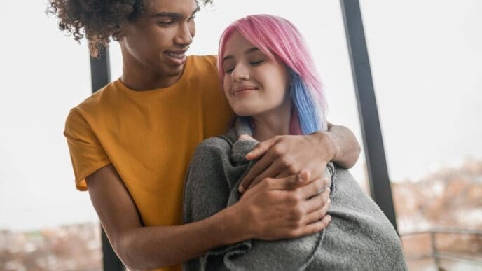 A young couple smiles while spending time together indoors.