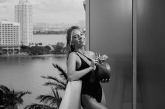 A young woman enjoys coconut juice on a summer vacation in Miami.