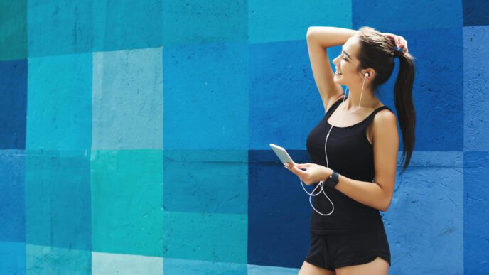 Woman choose music to listen in her mobile phone during workou