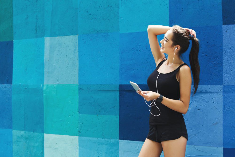 Woman choose music to listen in her mobile phone during workou