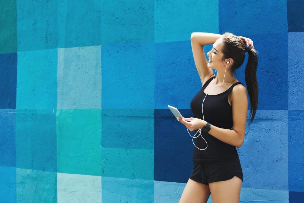 Woman choose music to listen in her mobile phone during workou