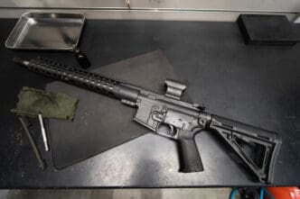 AR-15 rifle with red dot sight on a gunsmith's workbench