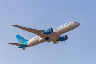 A Boeing 787-8 airplane from Air Tanzania takes off against a clear, blue sky