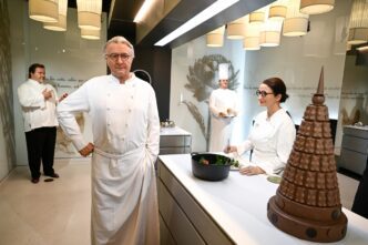 The wax statue of French chef Alain Ducasse stands in a museum kitchen exhibit