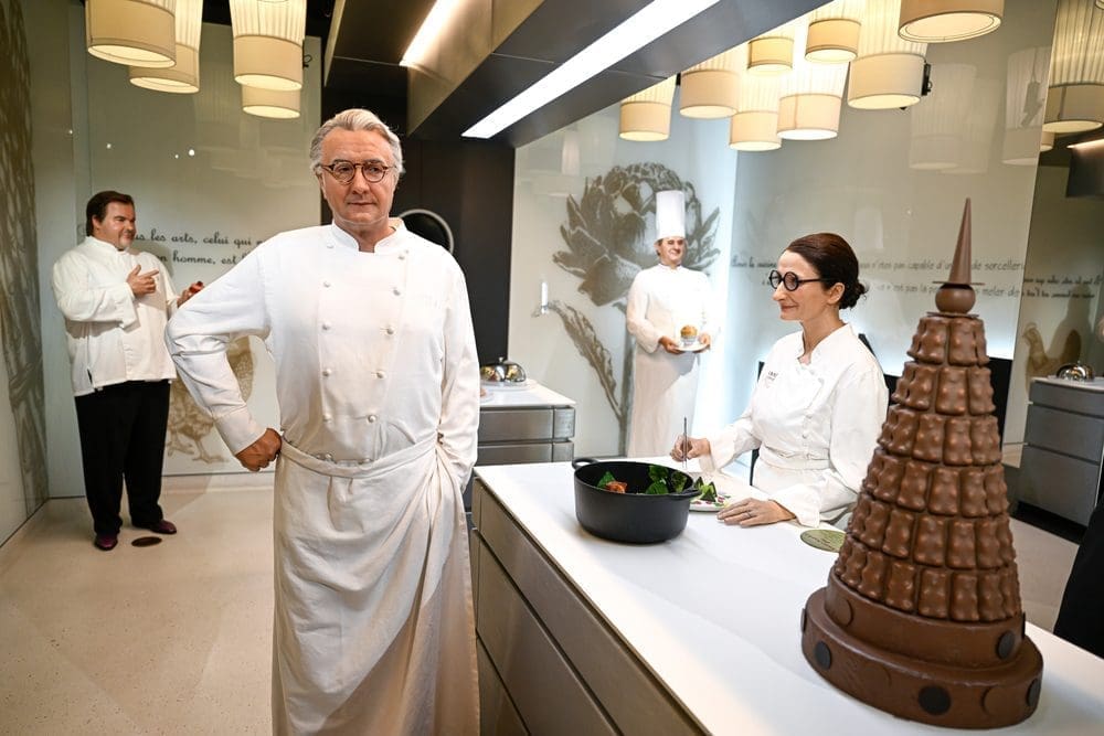 The wax statue of French chef Alain Ducasse stands in a museum kitchen exhibit